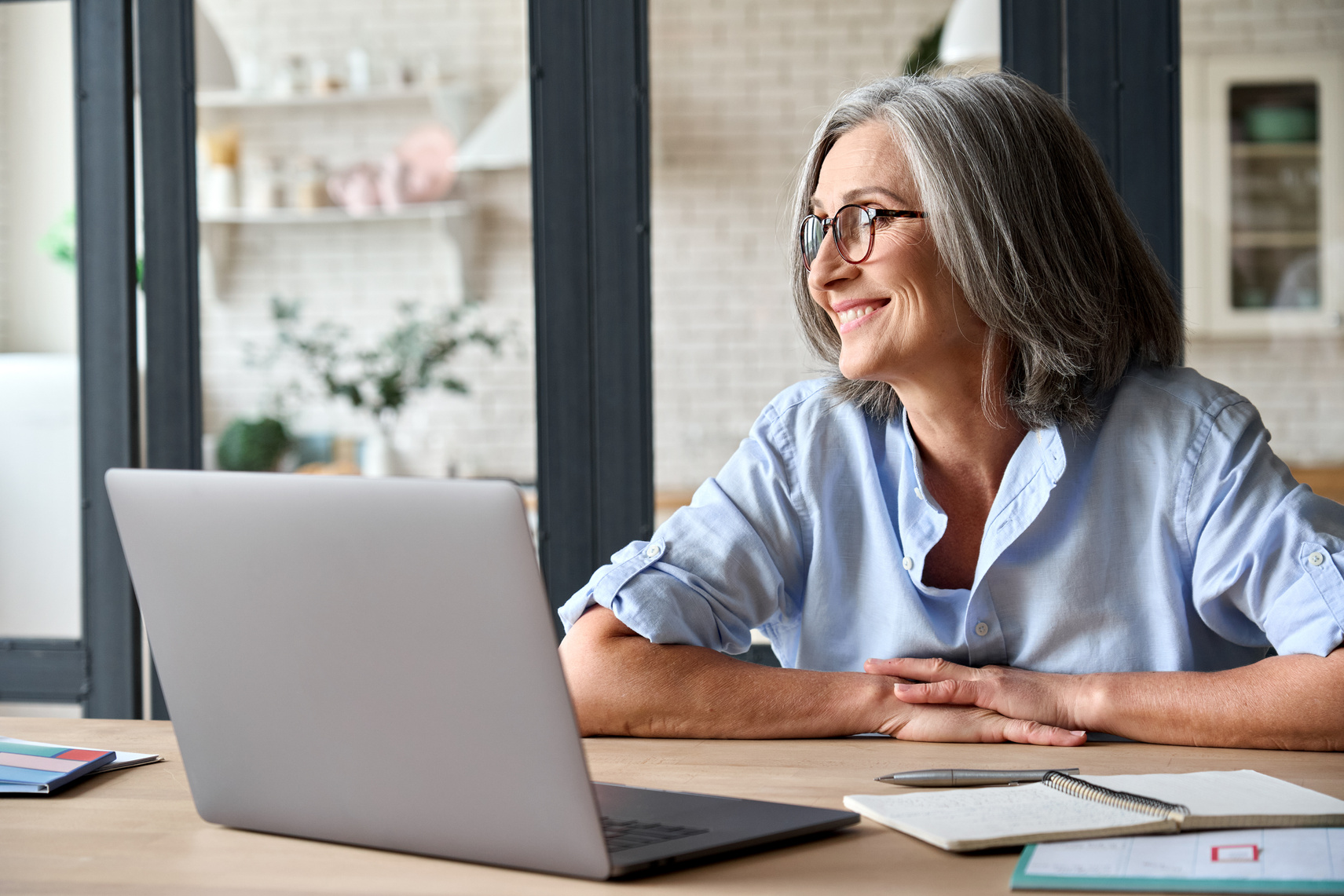 Senior Woman Sitting at Home with Computer Smiling